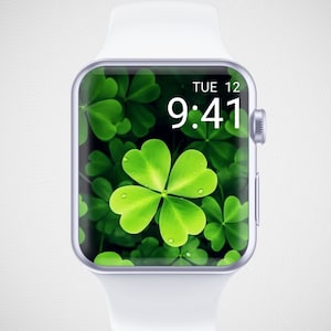 May include: A white Apple Watch with a silver case and a green clover leaf wallpaper. The time is 9:41 and the date is TUE 12.