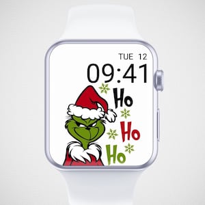 Könnte beinhalten: Eine weiße Smartwatch mit einem weihnachtlichen Ziffernblatt. Auf dem Bildschirm ist der grüne Grinch mit roter Weihnachtsmütze, dem Text "Ho Ho Ho" und Schneeflocken zu sehen. Die Uhrzeit ist 09:41. Ein modernes Accessoire.