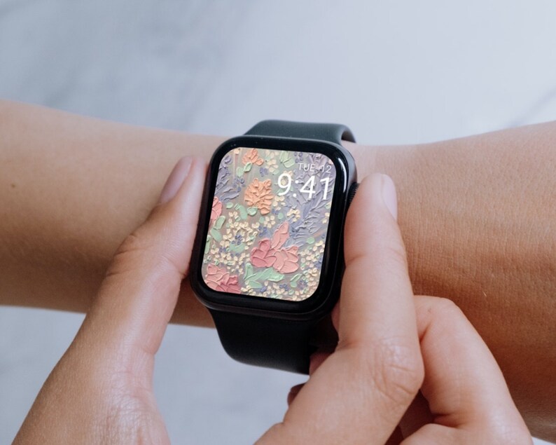 Może przedstawiać: Czarny smartwatch z kwiatowym cyferblatem. Godzina 9:41. Zegarek jest na nadgarstku osoby.