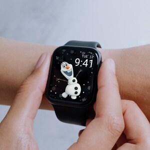 May include: A black smartwatch displaying a cartoon image of Olaf from Frozen. The watch face shows the time as 9:41 and the day as Tuesday. The watch is on a black band.