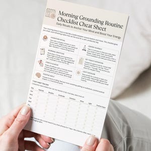 Close-up mock-up of the Morning Grounding Routine Checklist printable held in both hands, showing hydration, gratitude, movement, and tracker boxes.