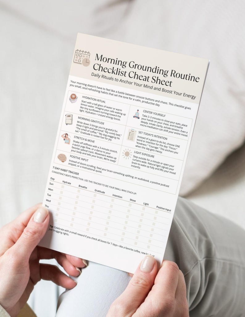 Close-up mock-up of the Morning Grounding Routine Checklist printable held in both hands, showing hydration, gratitude, movement, and tracker boxes.