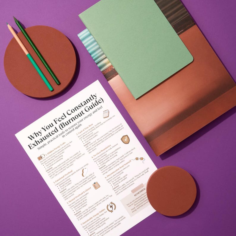 Op de afbeelding: Een platte lay-out met een gids getiteld "Waarom je je constant uitgeput voelt (Burn-outgids)", een groen notitieboek, een bruine coaster en twee potloden. De gids biedt praktische tools om energie te herstellen.