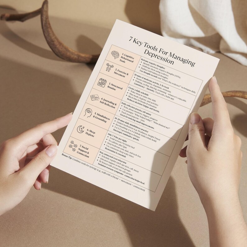 Person holding Depression Tools printable worksheet, beige CBT-based mental health cheat sheet for daily emotional support