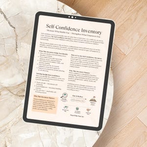 May include: A digital tablet displaying the "Self-Confidence Inventory" guide, with text about self-assessment and personal growth. The tablet rests on a light-colored, textured surface, with the screen's content clearly visible.