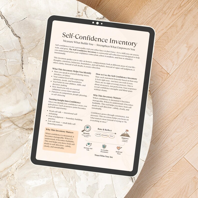 May include: A digital tablet displaying the "Self-Confidence Inventory" guide, with text about self-assessment and personal growth. The tablet rests on a light-colored, textured surface, with the screen's content clearly visible.