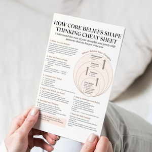 May include: A white paper titled "HOW CORE BELIEFS SHAPE THINKING CHEAT SHEET" is held by a person. The sheet explains how to understand and shift thought patterns. The text includes sections on core beliefs, patterns, and challenging them.