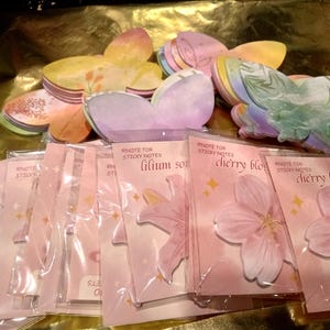 May include: A collection of butterfly-shaped sticky notes in various pastel colors and patterns, packaged in clear plastic sleeves. Each sleeve features the text Note for Sticky Notes, with labels for lilium son and cherry blossoms, including 30 sheets.
