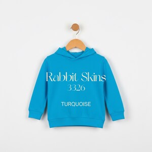 May include: A turquoise blue hoodie with the text "Rabbit Skins 3326 TURQUOISE". The hoodie is hanging on a wooden hanger against a white background. The hoodie has a hood and long sleeves.
