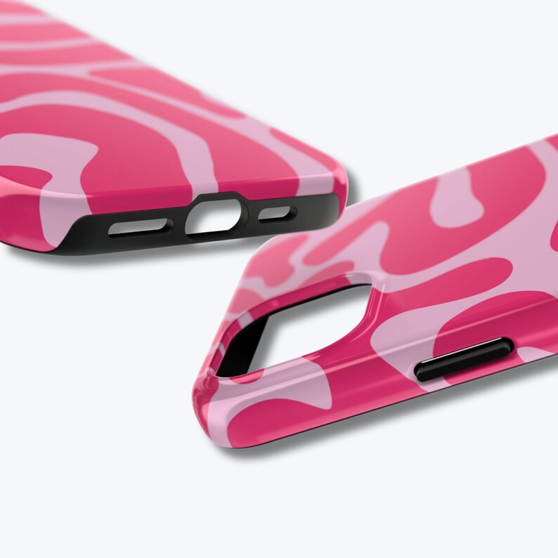 May include: Two pink phone cases with a wavy pattern in shades of pink. The cases have black edges and cutouts for the camera and charging port. The design is a modern, abstract style.