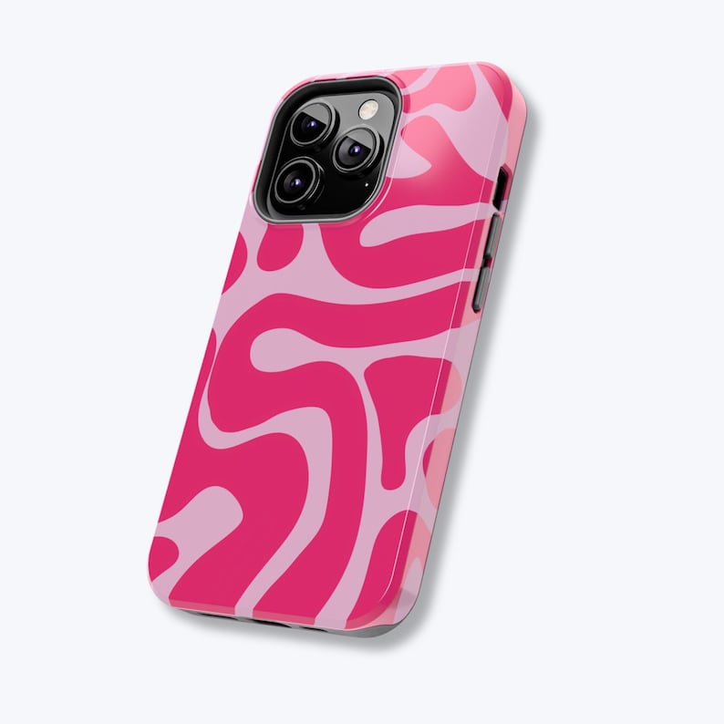 May include: A pink and light pink abstract patterned phone case. The case has a glossy finish and a black camera lens cutout. The design features flowing, wavy shapes in varying shades of pink.