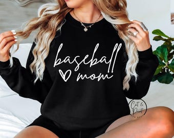 Può includere: Felpa nera con la scritta "baseball mom" in corsivo bianco, con un simbolo a forma di cuore bianco. L'immagine include anche il logo di "Cat & Print SVG Shop".