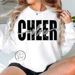 以下が含まれることがあります： 太字の黒い文字で「CHEER」、筆記体で「wolves」と書かれた白いスウェットシャツ。「Cut & Print SVG Shop」の文字も円で囲まれています。