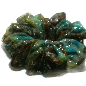 May include: A green, brown, and blue sparkly scrunchie.