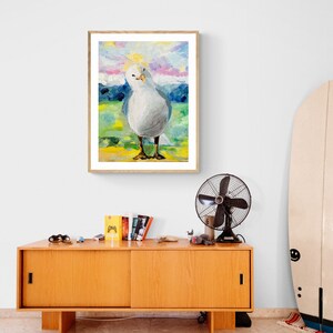 Op de afbeelding: Een schilderij van een witte meeuw met een gele snavel die op een geel en groen veld staat met een blauwe en paarse lucht op de achtergrond.