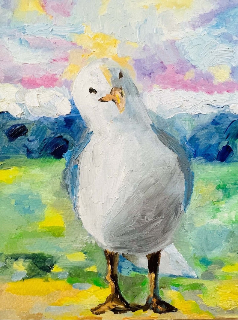 Op de afbeelding: Een witte meeuw met een gele snavel staat op een geel en groen grasveld met een blauwe en paarse lucht op de achtergrond.