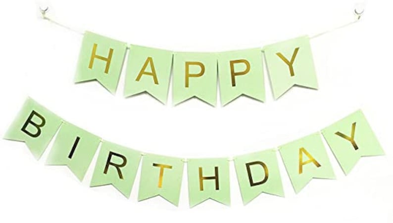 May include: A light green banner with gold lettering that reads "HAPPY BIRTHDAY". The banner is made of individual pennants strung together with a white string, perfect for birthday celebrations.