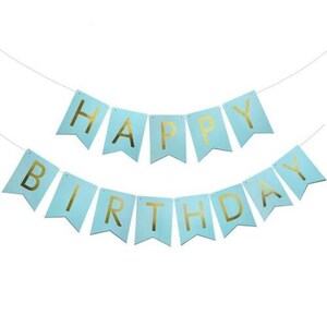 May include: A light blue banner with gold lettering spelling "HAPPY BIRTHDAY". The banner is made of individual pennant flags strung together on a white string. The background is plain white.