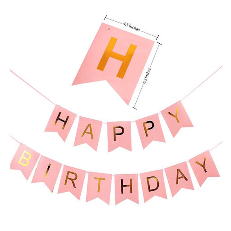 May include: Pink banner with gold lettering that reads "Happy Birthday." The banner is made of pink paper and has gold lettering. The banner is 6.5 inches long and 4.5 inches wide. The banner is for a birthday party.