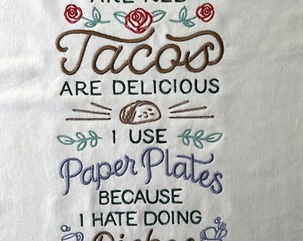 Embroidered apron with saying on white.