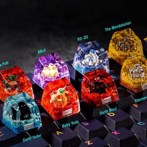 Puede incluir: Un conjunto de diez teclas de teclado con tem&aacute;tica de Star Wars, cada una con un personaje diferente de la franquicia. Las teclas est&aacute;n hechas de resina transparente y presentan detalles intrincados. Los personajes incluyen Boba Fett, BB-8, R2-D2, The Mandalorian, Baby Yoda, Darth Vader, Darth Maul y Stormtrooper.