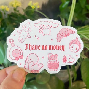 以下が含まれることがあります： ピンクと白のステッカーに、さまざまなキャラクターの漫画のイラストと「I have no money」というテキストが描かれています。