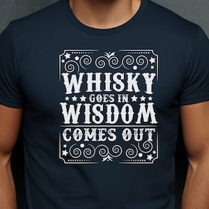 May include: A navy blue t-shirt with a white graphic design that reads "Whisky goes in Wisdom comes out" in a vintage style font.
