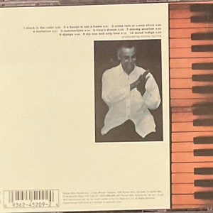 May include: A CD case with a white background and a black and white barcode. The text on the case reads: '1 black is the color 2 a house is not a home 3 come rain or come shine 4 a invitation 5 summertime 6 nica's dream 7 stormy weather 8 django 9 my one and only love 10 wood indigo produced by jimmy lovine'.