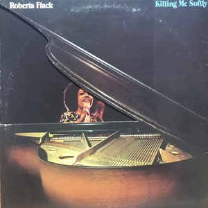 May include: A black and white album cover with the title "Killing Me Softly" and the artist's name "Roberta Flack". The cover features a woman singing in front of a grand piano with the lid open.