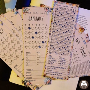 Könnte beinhalten: Ein Satz von fünf floral gemusterten, druckbaren Buchtrackern zur Aufzeichnung des Leseprozesses. Jeder Tracker verfügt über ein Kalenderrraster mit Feldern zum Markieren gelesener Bücher, ein Bewertungssystem und einen Bereich zur Aufzeichnung der Anzahl der gelesenen Seiten. Die Tracker sind mit den Monaten Januar, Februar, September und Oktober sowie einem Ganzjahres-Tracker mit allen 12 Monaten beschriftet.