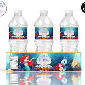 May include: Three clear water bottles with custom labels featuring a mermaid theme. The labels include the name "Olivia" and the number "2" in a seashell design. The bottom of the image shows a matching decorative wrap.