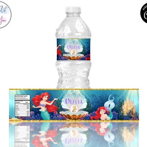 May include: A water bottle with a custom label featuring a mermaid theme. The label includes the name "Olivia" and the number "2" in a seashell design. The background is a vibrant underwater scene with mermaids and a castle.