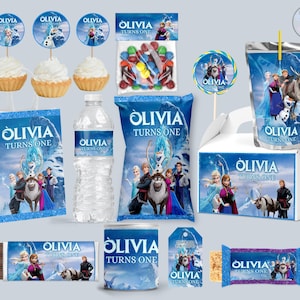 Puede incluir: Un conjunto de artículos para fiestas con los personajes de la película Frozen. Incluye cupcakes, caramelos, una botella de agua, una caja de zumo, una bolsa de regalo, una barra de chocolate y una bolsa de patatas fritas, con el nombre "Olivia" y "Turns One".
