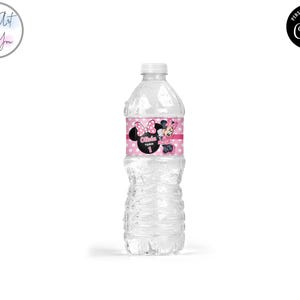 K&ouml;nnte beinhalten: Eine transparente Plastikwasserflasche mit wei&szlig;em Verschluss. Das Etikett zeigt einen rosa Hintergrund mit Polka Dots, Minnie Mouse-Grafiken und den Namen "Olivia" mit der Zahl "1". Die Flasche hat ein strukturiertes Design.