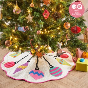 Peut inclure: Une jupe de sapin de Noël matelassée blanche avec un bord festonné rose. La jupe présente cinq ornements d'ampoules colorées avec des cordons noirs.