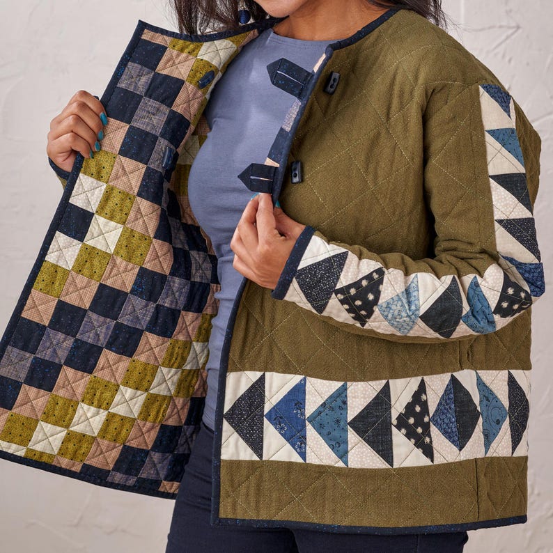 Puede incluir: Chaqueta acolchada verde oliva con dise&ntilde;o patchwork. La chaqueta presenta un patr&oacute;n de diamantes, con tri&aacute;ngulos y cuadrados de patchwork en tonos azules, blancos y beige. Tiene cierre de botones y ribete azul oscuro en contraste.