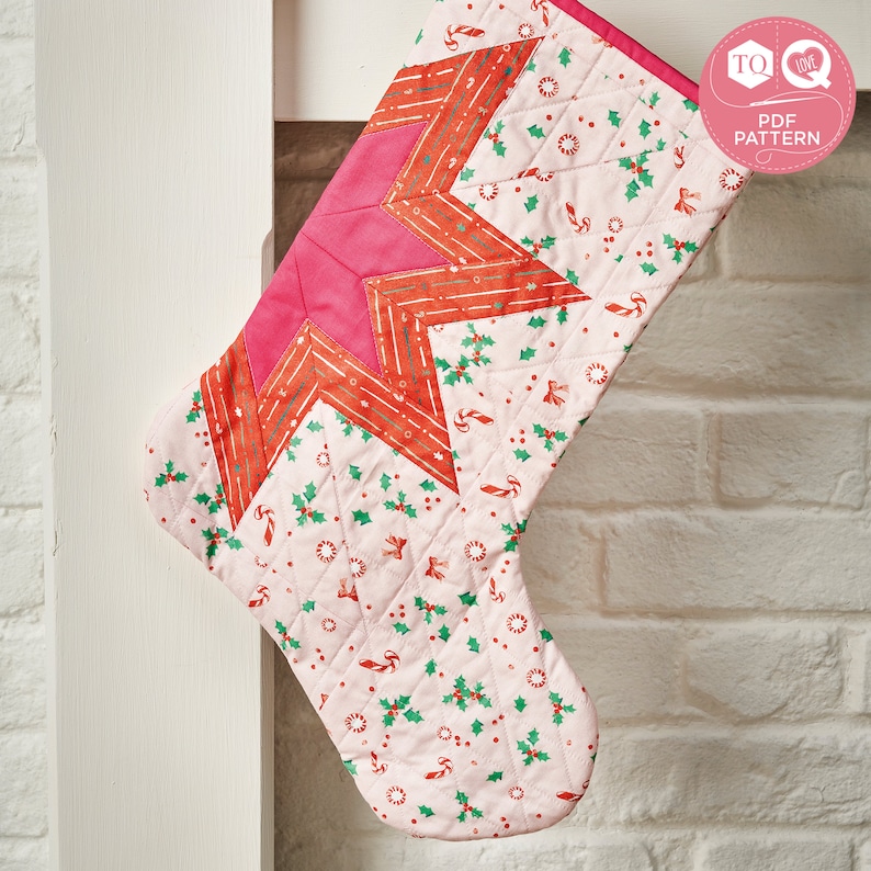 May include: A pink and red quilted Christmas stocking with a star design and a white background with a pattern of holly, candy canes, and dots. The stocking is hanging on a white brick wall. The text "TO LOVE PDF PATTERN" is in a red circle with a white heart.