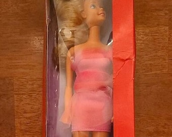 May include: A vintage Barbie doll in a pink dress with a white trim. The box features the text "Special Expressions" and "Barbie" in a bold, white font. The doll's blonde hair is styled in a ponytail. The box is red with a purple background.