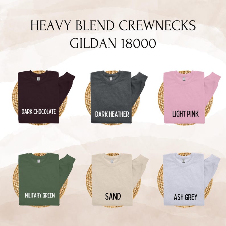 May include: A display of six crewneck sweatshirts in various colors: dark chocolate, dark heather, light pink, military green, sand, and ash grey. The text "HEAVY BLEND CREWNECKS GILDAN 18000" is at the top.