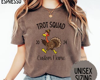 May include: Espresso-colored t-shirt with the text "Trot Squad 2024" and a cartoon turkey wearing a hat. The shirt also includes the words "Custom Name" and "Unisex Sizing".