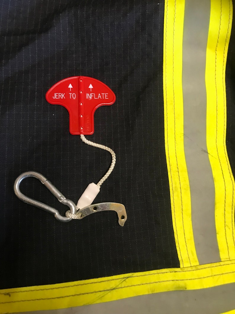 May include: A red safety device with a pull tab and a hook. The device has the words "Jerk to Inflate" printed on it.