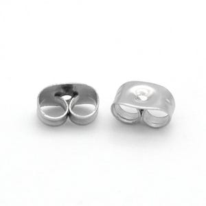 May include: Two silver earring backs. Each back has a butterfly shape with two loops and a central hole for the earring post. The backs are made of a shiny, metallic material.
