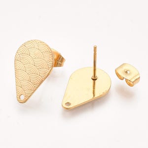 May include: Gold-coloured teardrop-shaped earring studs. One earring features a textured, wave-like pattern. The image shows the front, back, and earring backings. The earrings are on a white background.