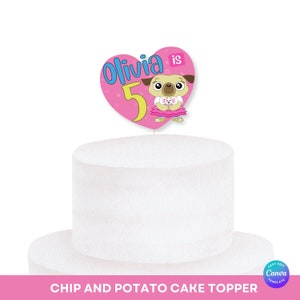 May include: A pink heart-shaped cake topper featuring a cartoon pug wearing a pink dress and holding a small white dog. The topper reads "Olivia is 5" in blue and yellow lettering.