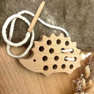 Threading game in the shape of a little hedgehog, learning through play with Montessori toys for children from NoriKids