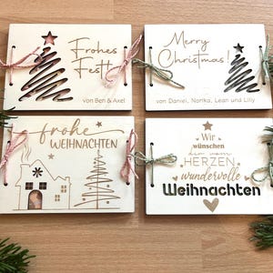 May include: Four wooden Christmas cards with festive designs and text. Each card features a unique design, including a Christmas tree, house, and holiday greetings. The cards are tied with twine and are perfect for holiday gifting.