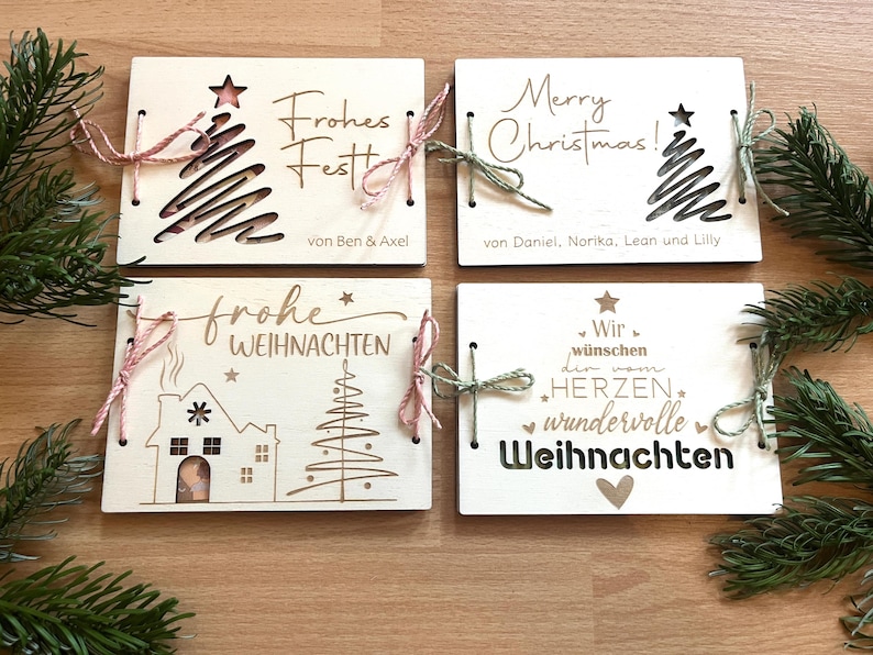 May include: Four wooden Christmas cards with festive designs and text. Each card features a unique design, including a Christmas tree, house, and holiday greetings. The cards are tied with twine and are perfect for holiday gifting.