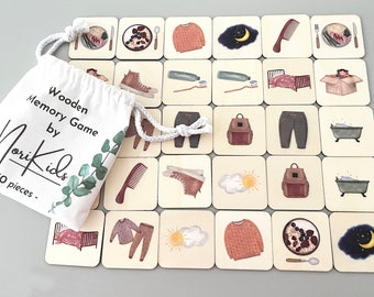 May include: A wooden memory game with 30 pieces in a white drawstring bag. The game features illustrations of everyday activities, such as getting ready for bed, brushing teeth, and eating breakfast. The bag has the text "Wooden Memory Game by MoriKids - 30 pieces -" printed on it.