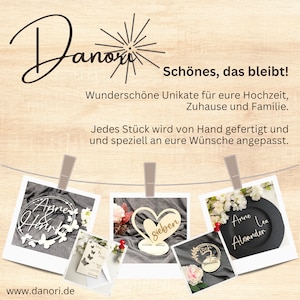 May include: An advertisement for Danori features several custom wooden wedding decorations. The image includes a heart-shaped sign, a circular sign with butterflies, and a black slate sign. The text on the image says "Sch&ouml;nes, das bleibt!" and "www.danori.de".
