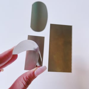 May include: A set of three metal cake decorating tools. The tools are made of stainless steel and have different shapes. The tools are used to create different designs on cakes.